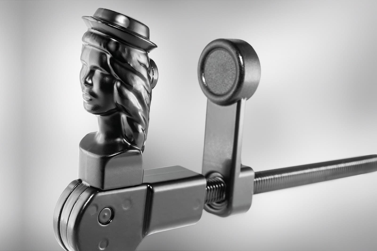 Klappladenhalter in Form eines Frauenkopfs neben einem Magnethalter
